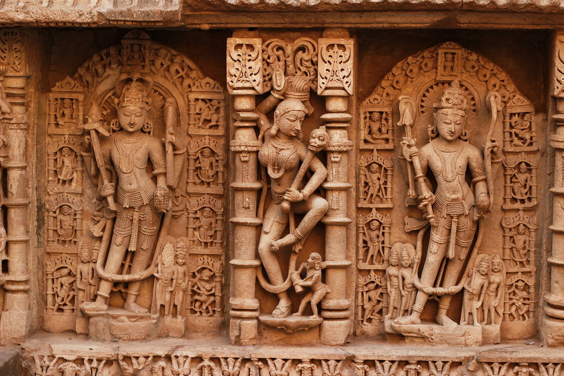 Three sculpture niches on the wall of Rani-ki-Vav at Patan, the eleventh-century stepwell UNESCO calls an inverted temple, carved in warm sandstone