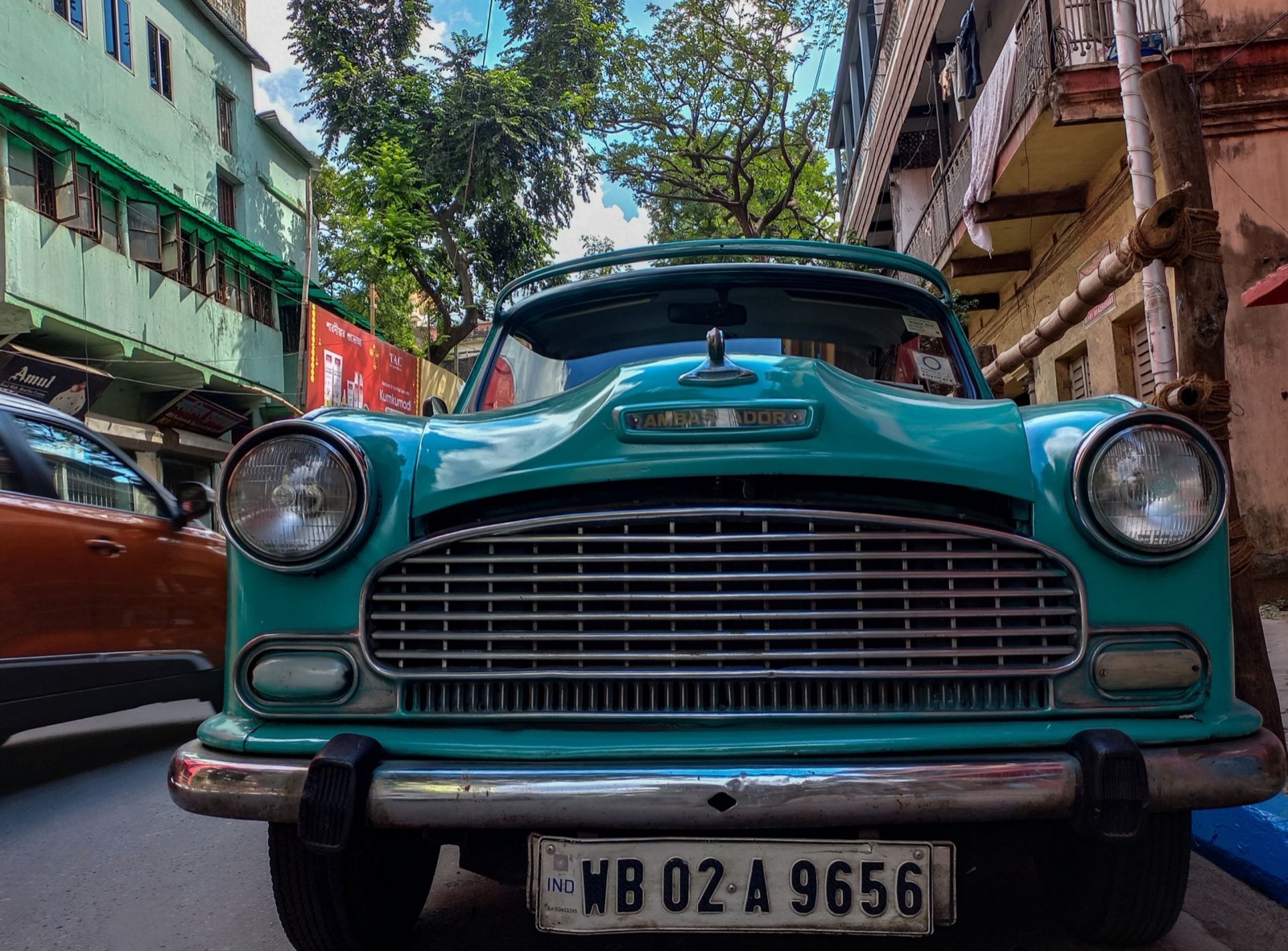 A vintage Ambassador taxi on a Kolkata street, colonial-era buildings behind