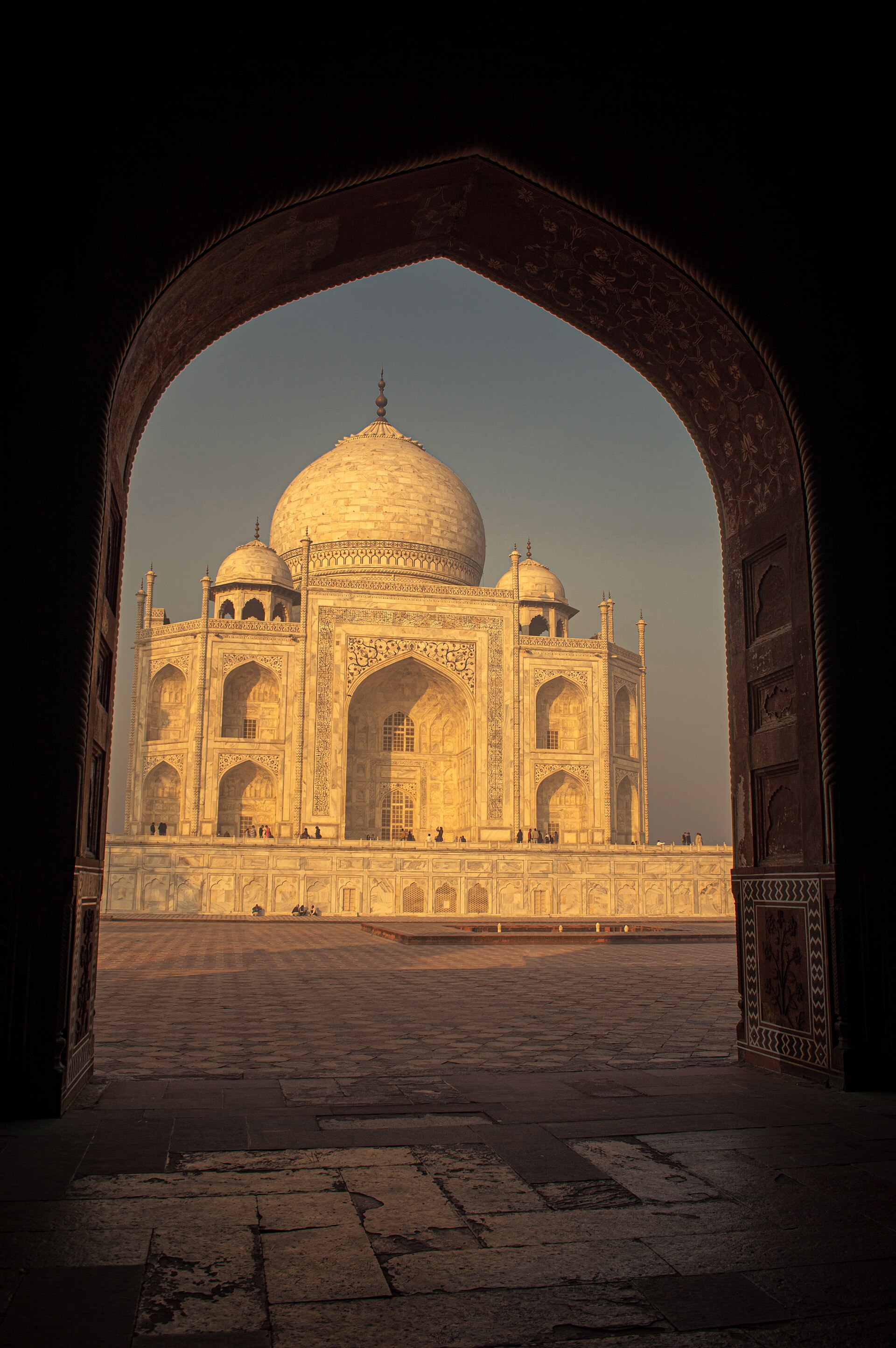The Taj Mahal framed through an archway in golden sunrise light, Agra